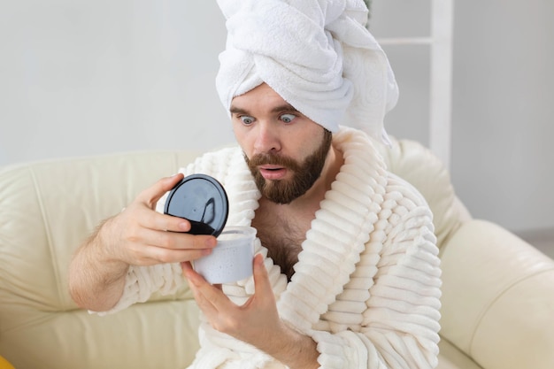 Retrato de hombre aplicando crema eficaz en su spa de piel facial en casa cuidado del cuerpo y la piel para hombres