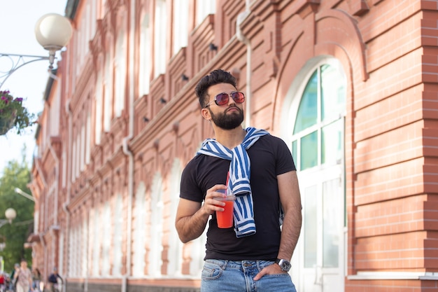 Retrato de un hombre árabe elegante joven inconformista con jugo. Vacaciones urbanas en el concepto de fin de semana.