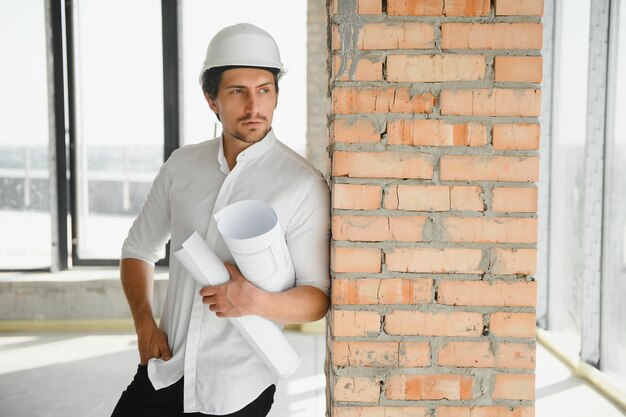 Retrato de hombre arquitecto en el sitio de construcción Gerente de construcción confiado usando casco Ingeniero civil maduro exitoso en el sitio de construcción con espacio de copia