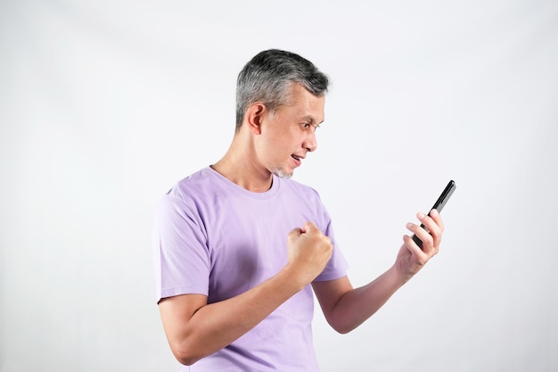 Retrato de un hombre asiático con camiseta morada se ve feliz con el teléfono