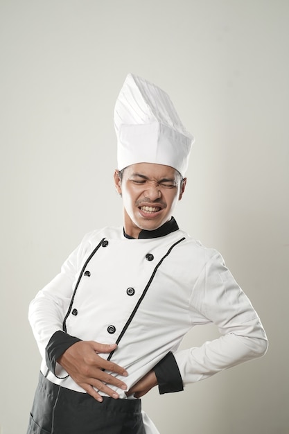 Retrato de hombre asiático chef sintiendo dolor de espalda sobre fondo blanco aislado