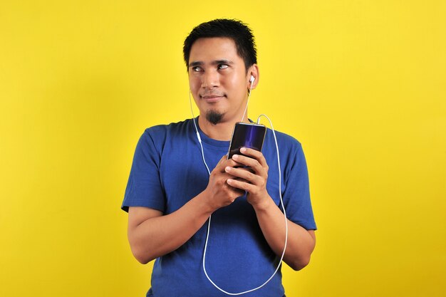 Retrato de hombre asiático emocionado sorprendido al encontrar una canción de tendencia en línea