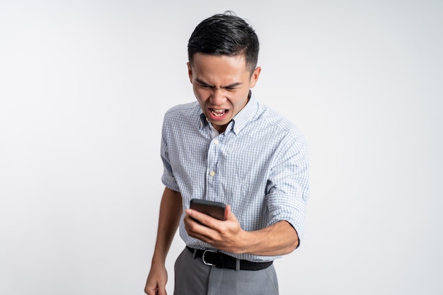 Retrato de hombre asiático enojado con su teléfono