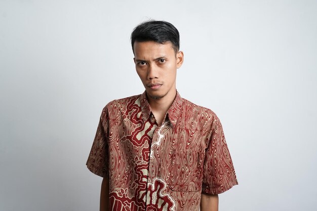 Foto un retrato de un hombre asiático feliz con camisa batik sonríe aislado de fondo blanco