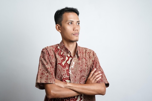 Un retrato de un hombre asiático feliz con camisa batik sonríe aislado de fondo blanco