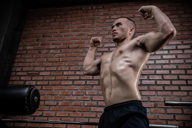 Retrato de un hombre asiático con grandes músculos en el gimnasioGente de TailandiaEntrenamiento para una buena saludEntrenamiento de peso corporalFitness en el concepto de gimnasio