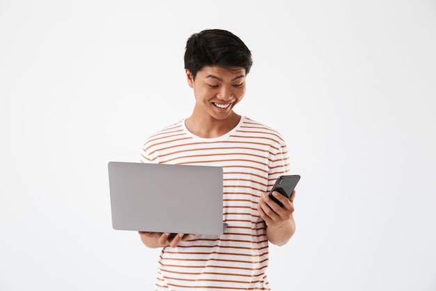 Retrato de un hombre asiático joven feliz con portátil
