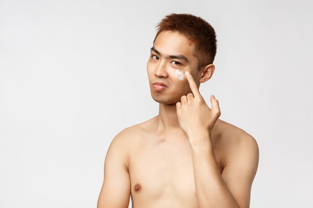 Retrato de un hombre asiático joven que muestra gesto.