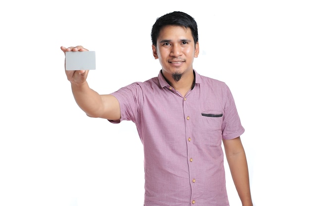 Retrato de hombre asiático sonriente sosteniendo una tarjeta de presentación en blanco sobre fondo blanco.