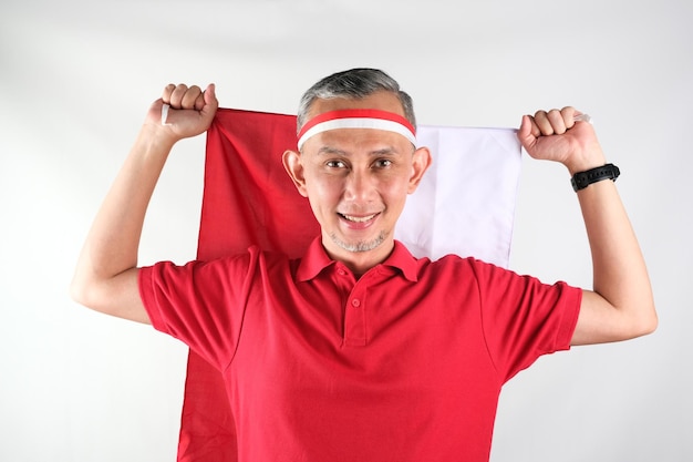 Retrato de un hombre asiático sosteniendo el atributo rojo y blanco de la bandera de Indonesia Concepto del Día de la Independencia