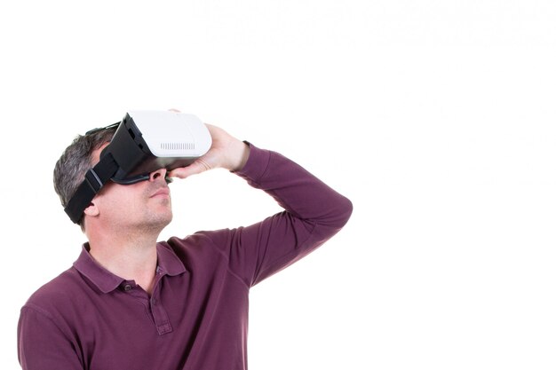 Retrato de un hombre asombrado usando un casco de realidad virtual aislado en blanco