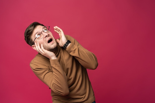 Retrato del hombre asustado aislado sobre fondo rosa de moda.