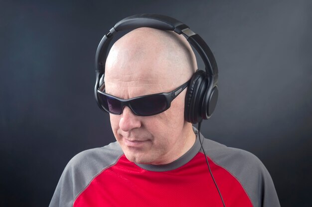 Retrato de un hombre con auriculares en la cabeza en relajación escuchando música