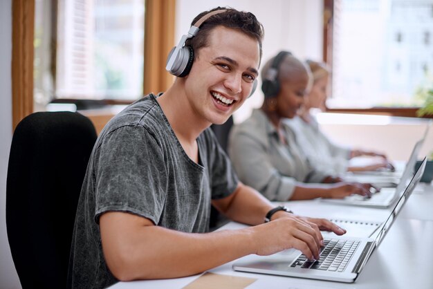 Retrato de hombre y auriculares con felices como agente o asesor financiero en una compañía de seguros Sonrisa de persona masculina y portátil en un edificio de oficinas y empresa en un espacio de coworking negocio o servicio al cliente