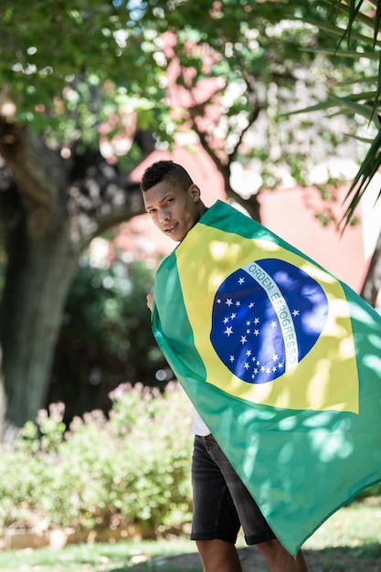 Foto retrato de un hombre con una bandera brasileña al aire libre