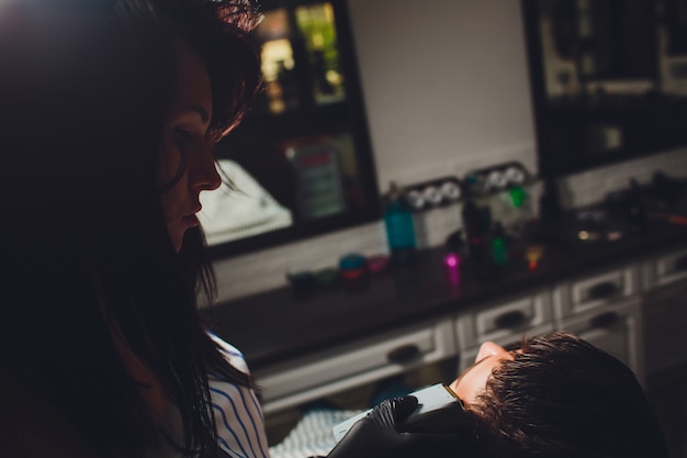 Retrato de hombre barba en peluquería. Mano femenina