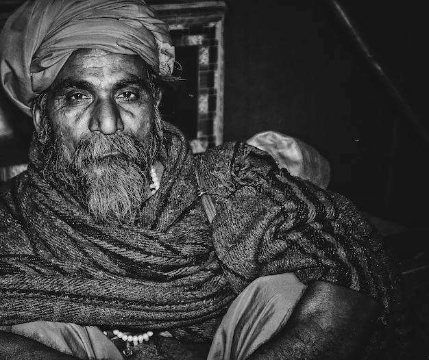 Retrato de un hombre con barba sentado al aire libre por la noche