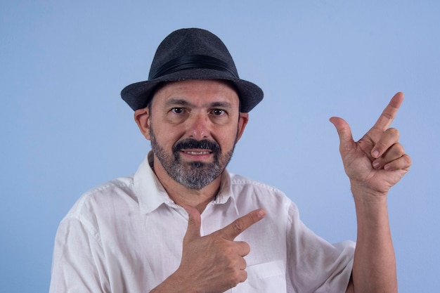 Retrato de hombre barbudo de 60 años sobre fondo azul.