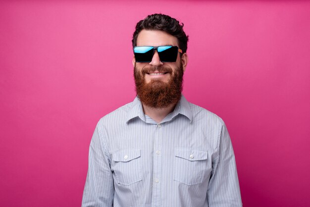 Retrato de hombre barbudo alegre en gafas de sol casuales