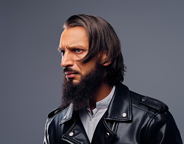 Retrato de hombre barbudo con cabello largo vestido con una chaqueta de cuero negro.