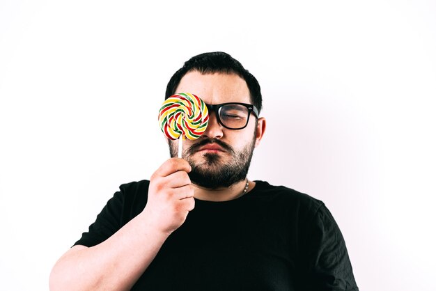 Retrato de un hombre barbudo con gafas con una gran paleta redonda