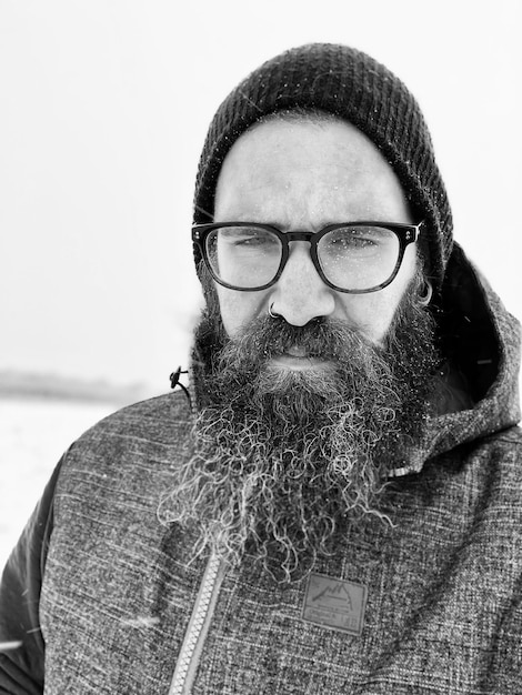 Foto retrato de un hombre barbudo con gafas y ropa cálida durante el invierno