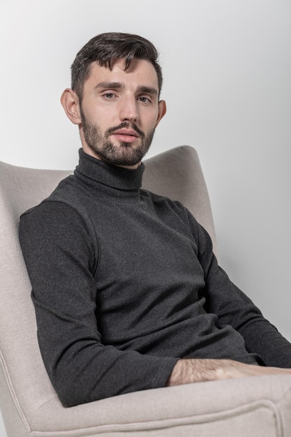 Retrato de un hombre barbudo guapo caucásico sentado en la silla