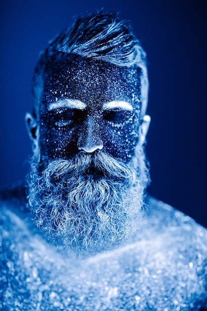 Retrato de un hombre barbudo. El hombre está pintado con polvo ultravioleta.