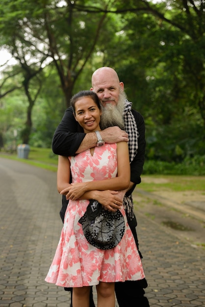 Retrato de hombre barbudo maduro y mujer asiática madura como pareja casada