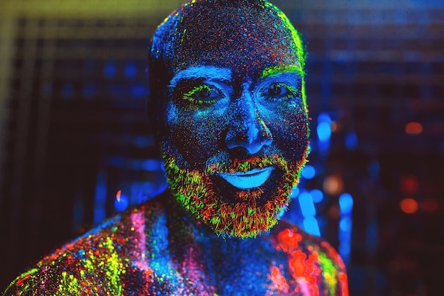 Retrato de un hombre barbudo pintado en polvo fluorescente.