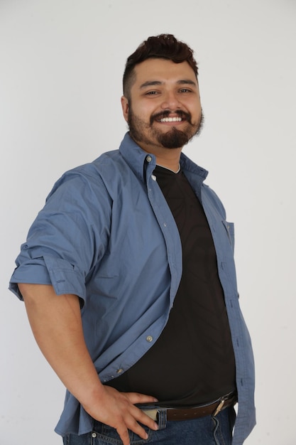 Foto retrato de un hombre barbudo sonriente de pie contra un fondo blanco