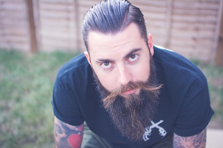 Foto retrato de un hombre barbudo con tatuajes
