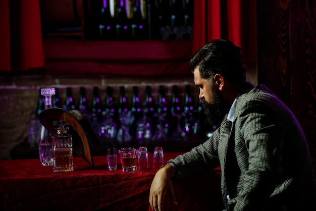 Retrato de un hombre barbudo con un vaso de alcohol en las manos Descanso y relajación en pub o bar