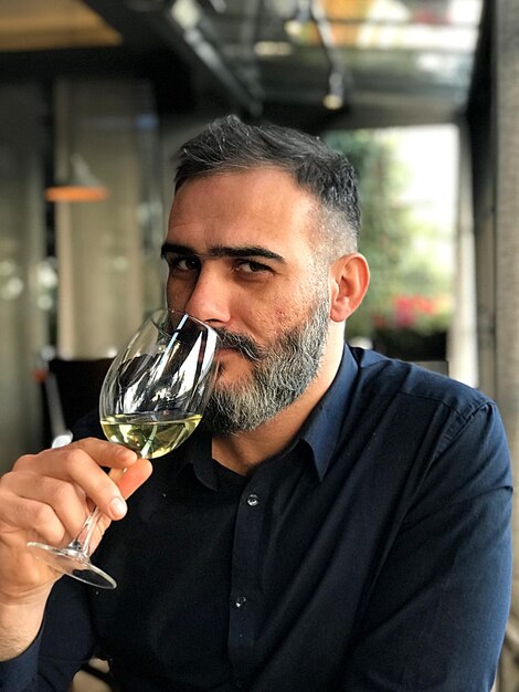 Retrato de un hombre bebiendo vino en un restaurante