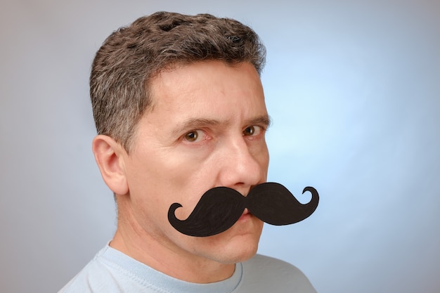 Retrato de un hombre con bigote falso para asistir a un evento en noviembre para ayudar a los hombres a conocer los problemas de salud.