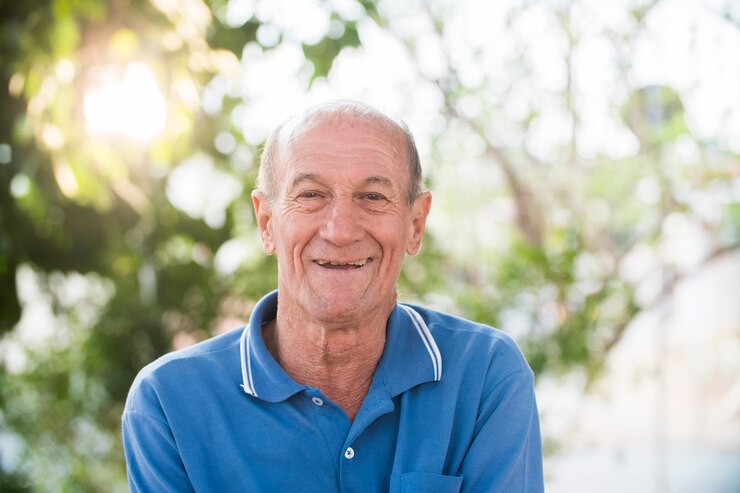Retrato de hombre brasileño senior mirando a cámara en puesta de sol y sonriendo. Forma horizontal, copie el espacio.