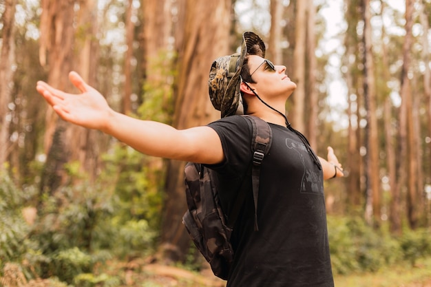 Retrato de un hombre con los brazos abiertos disfrutando del aire de la selva