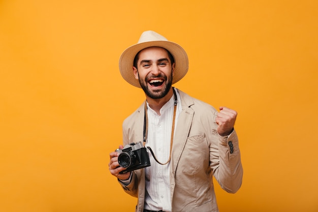 Retrato de hombre de buen humor posando con cámara retro