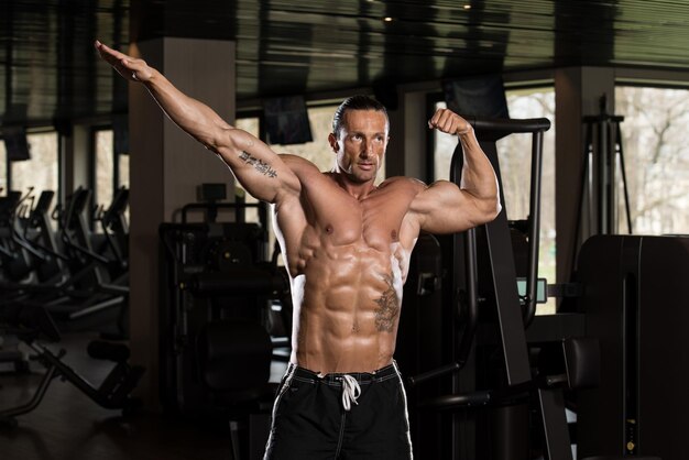 Retrato de un hombre en buena forma física en el moderno gimnasio