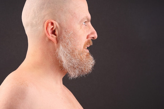 Retrato de un hombre calvo y barbudo de perfil