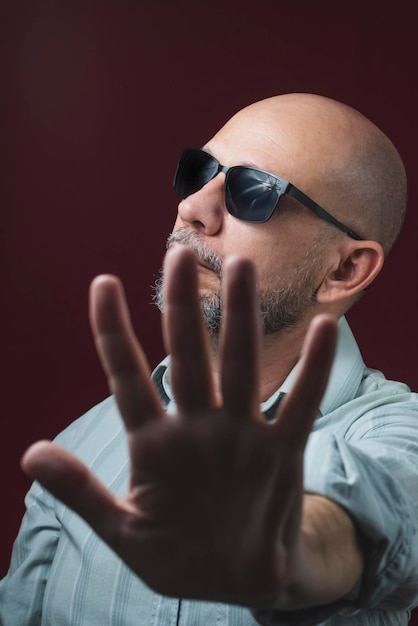 Retrato de un hombre calvo y barbudo que llevaba gafas contra un fondo rojo oscuro Salvador Bahía Brasil