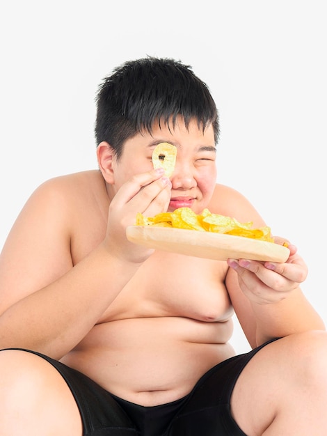 Foto retrato de un hombre sin camisa comiendo contra un fondo blanco