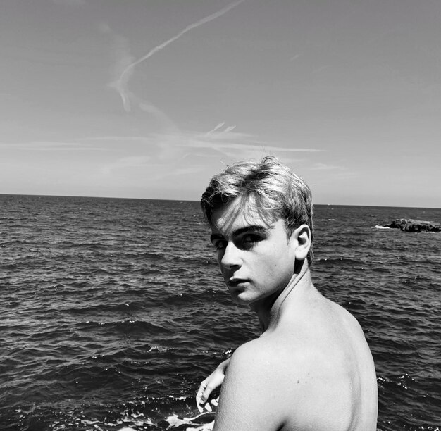 Foto retrato de un hombre sin camisa contra el mar contra el cielo