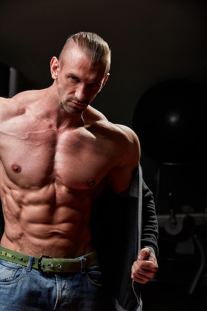 Retrato de un hombre sin camisa haciendo ejercicio en el gimnasio