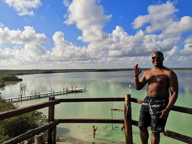 Retrato de un hombre sin camisa de pie contra el mar