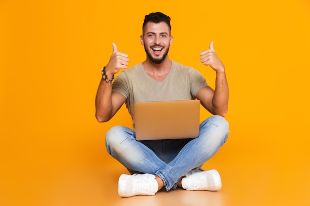 Retrato de un hombre casual joven feliz sentado