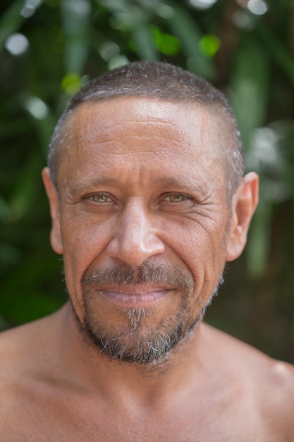 Foto retrato de un hombre caucásico feliz descansando sobre un fondo de hojas verdes en un jardín tropical en la naturaleza, cerrar