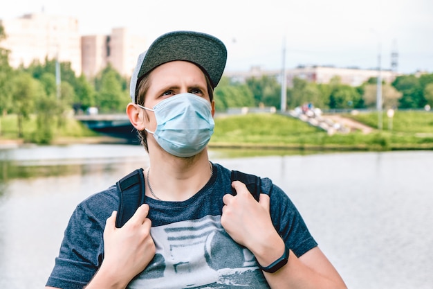 Retrato de un hombre caucásico en una máscara médica durante una pandemia en la ciudad. Nueva normalidad.