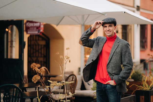 Retrato de un hombre con chaqueta y gorra en una calle de otoño de la ciudad