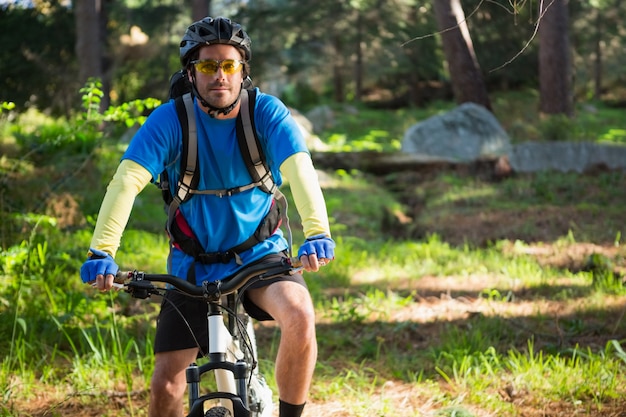 Retrato de hombre ciclista de montaña con bicicleta en el bosque